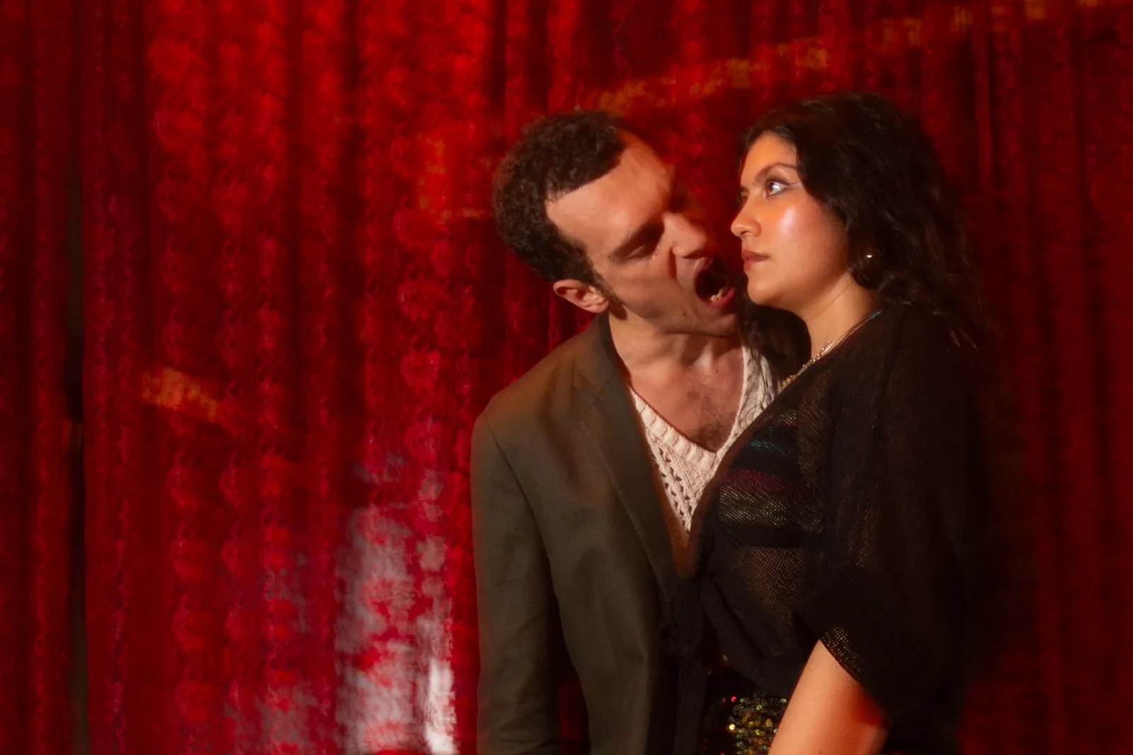 Two-page magazine spread pairing a woman in a floral headscarf and round sunglasses with a crouching figure in black cat-eye sunglasses and feathered wings.